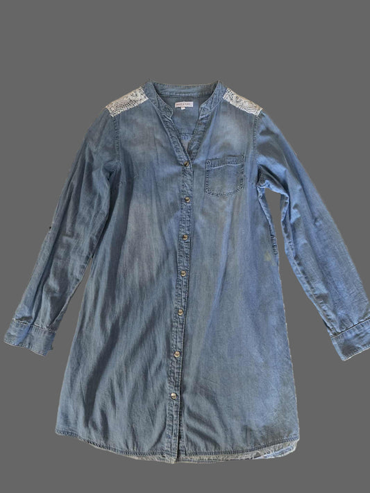 Blue denim dress with lace details on a textured surface