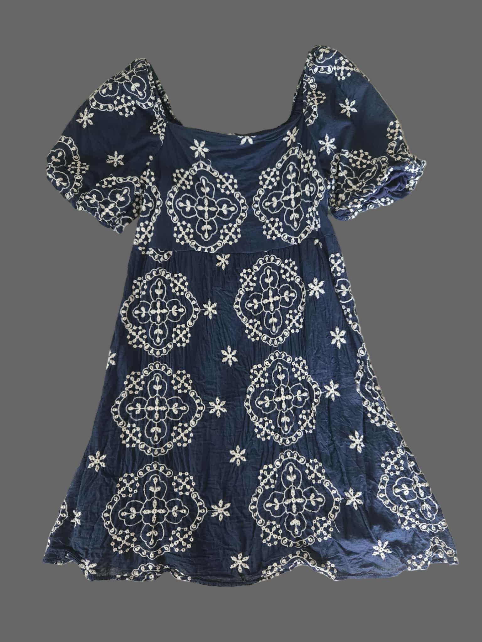 Navy blue dress with white patterns on a textured surface