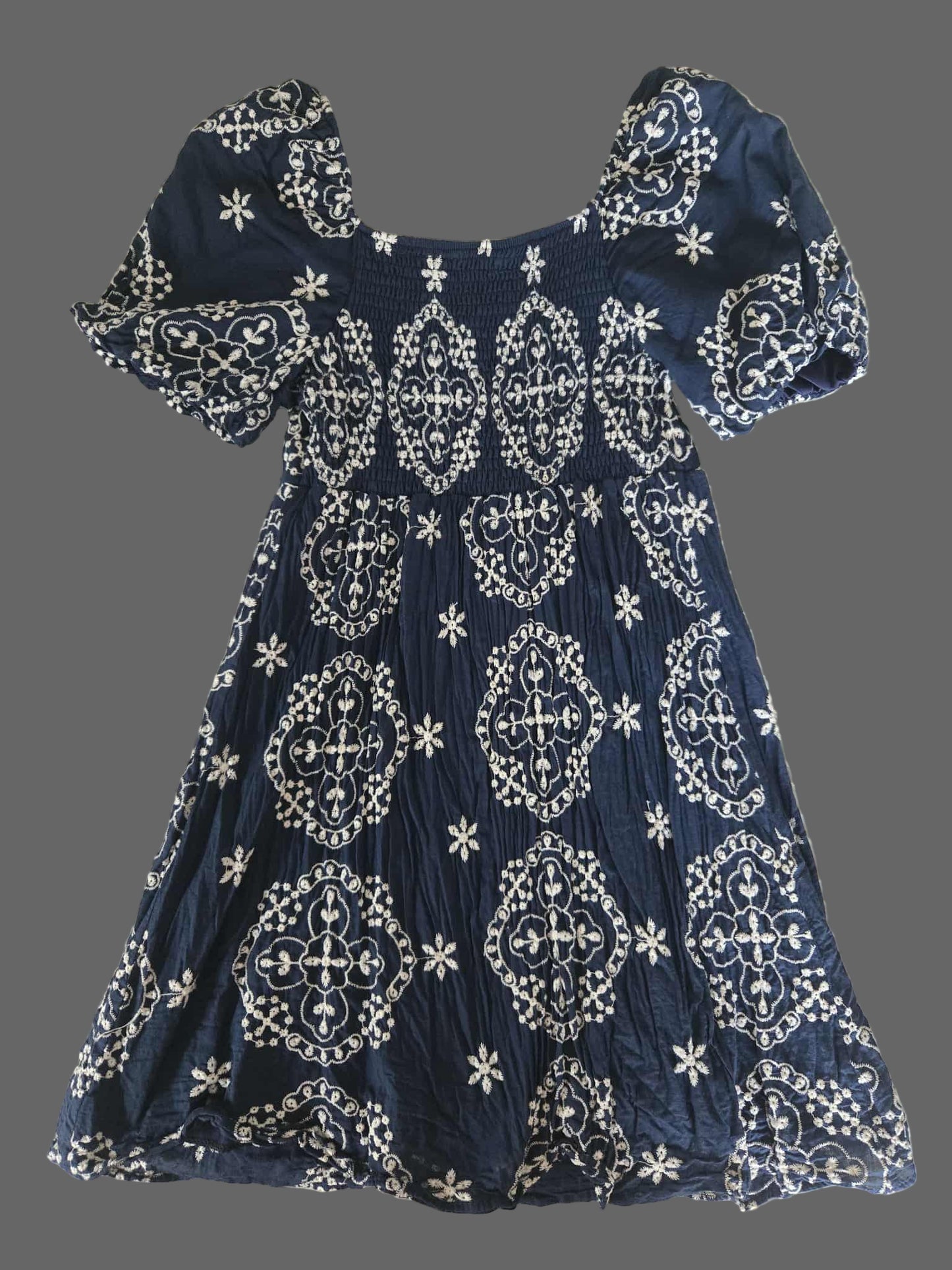 Navy blue dress with white patterns on a textured surface