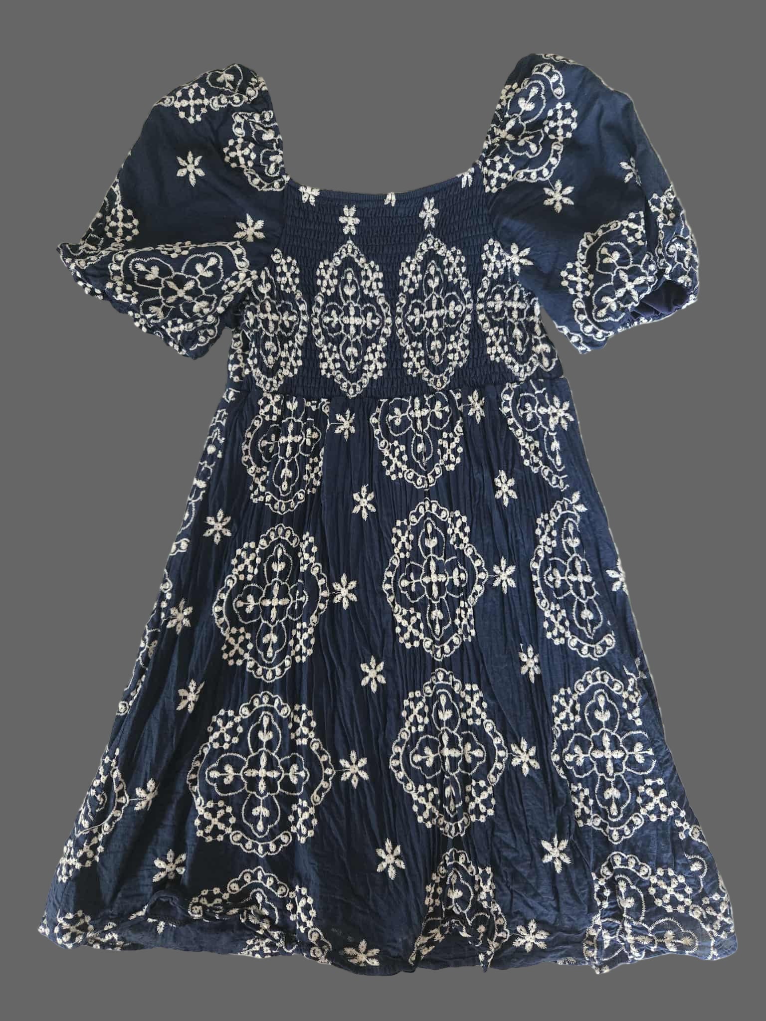 Navy blue dress with white patterns on a textured surface