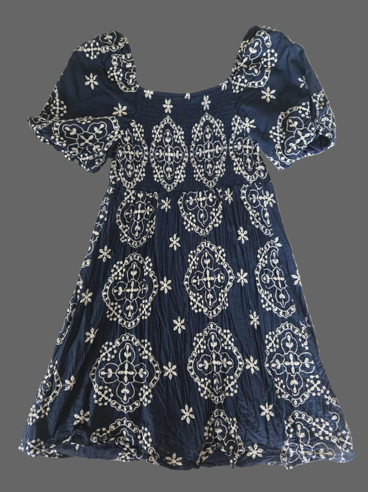 Navy blue dress with white patterns on a textured surface